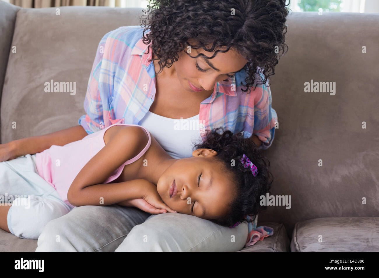 Niedliche Tochter auf Mütter Schoß auf dem Sofa schlafen Stockfoto