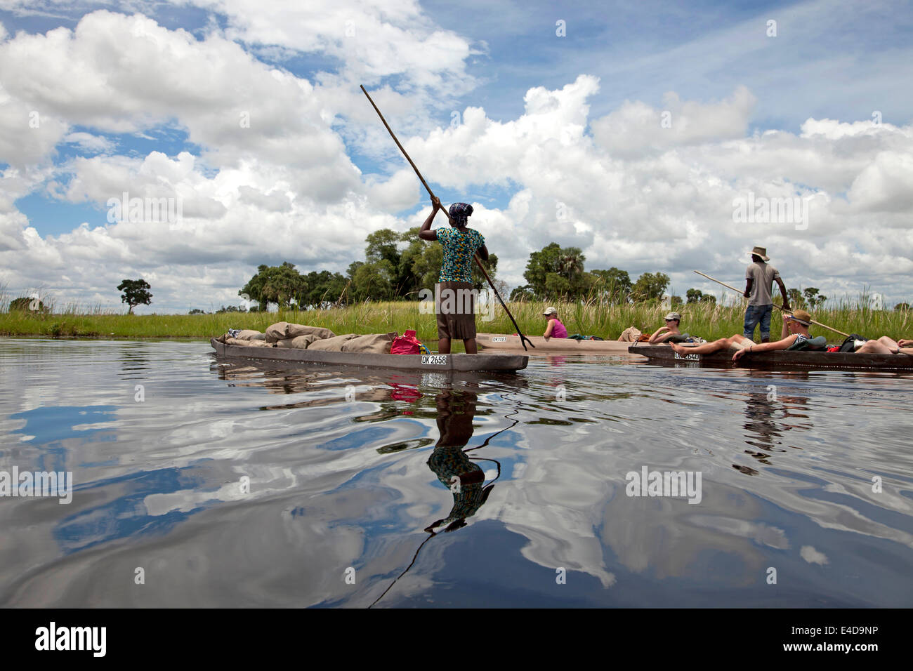 Touristen auf einem traditionellen Mokoro Boot in das Okavango Delta, Botswana, Afrika Stockfoto