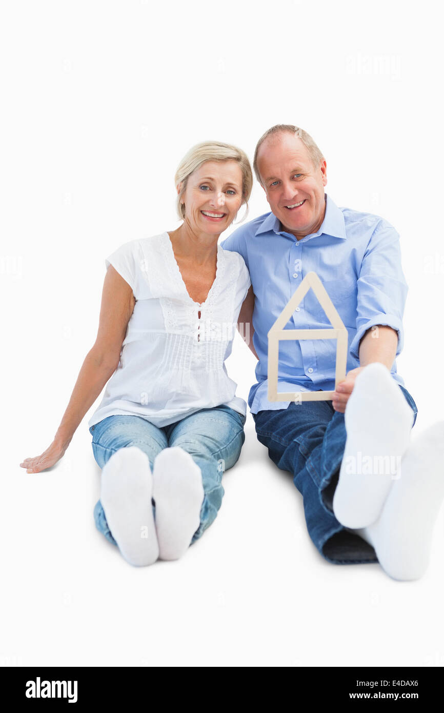 Gerne älteres Paar hält eine Haus-Form Stockfoto
