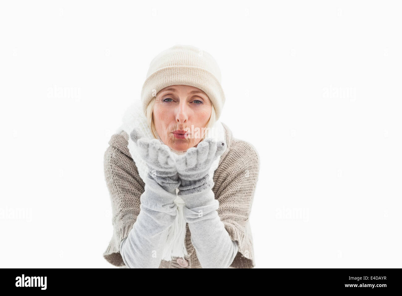 Reife Frau in Winterkleidung weht Kuss Stockfoto