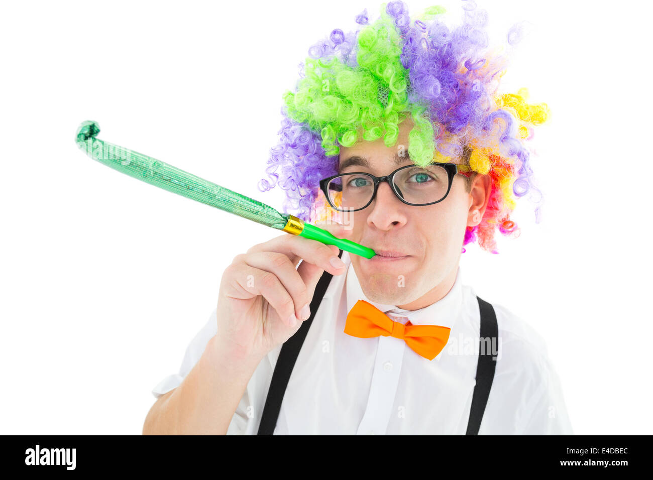 Geeky Hipster tragen eine Regenbogen-Perücke Party Horn bläst Stockfoto