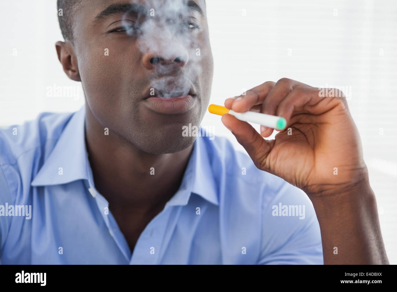 Unternehmer, die eine elektronische Zigarette rauchen Stockfoto