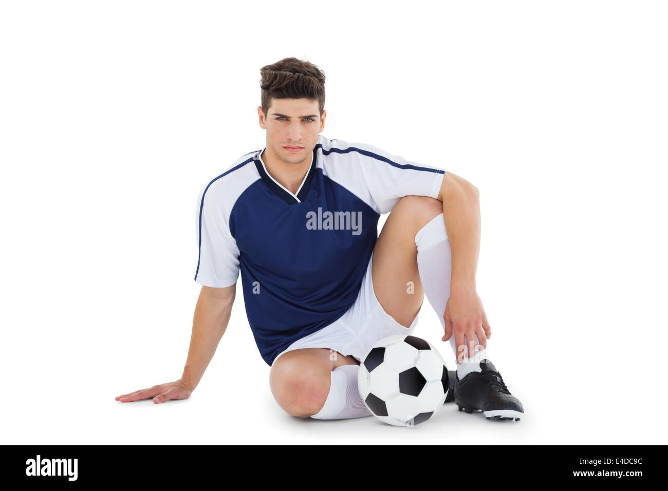 Football-Spieler sitzen auf dem Boden mit ball Stockfoto