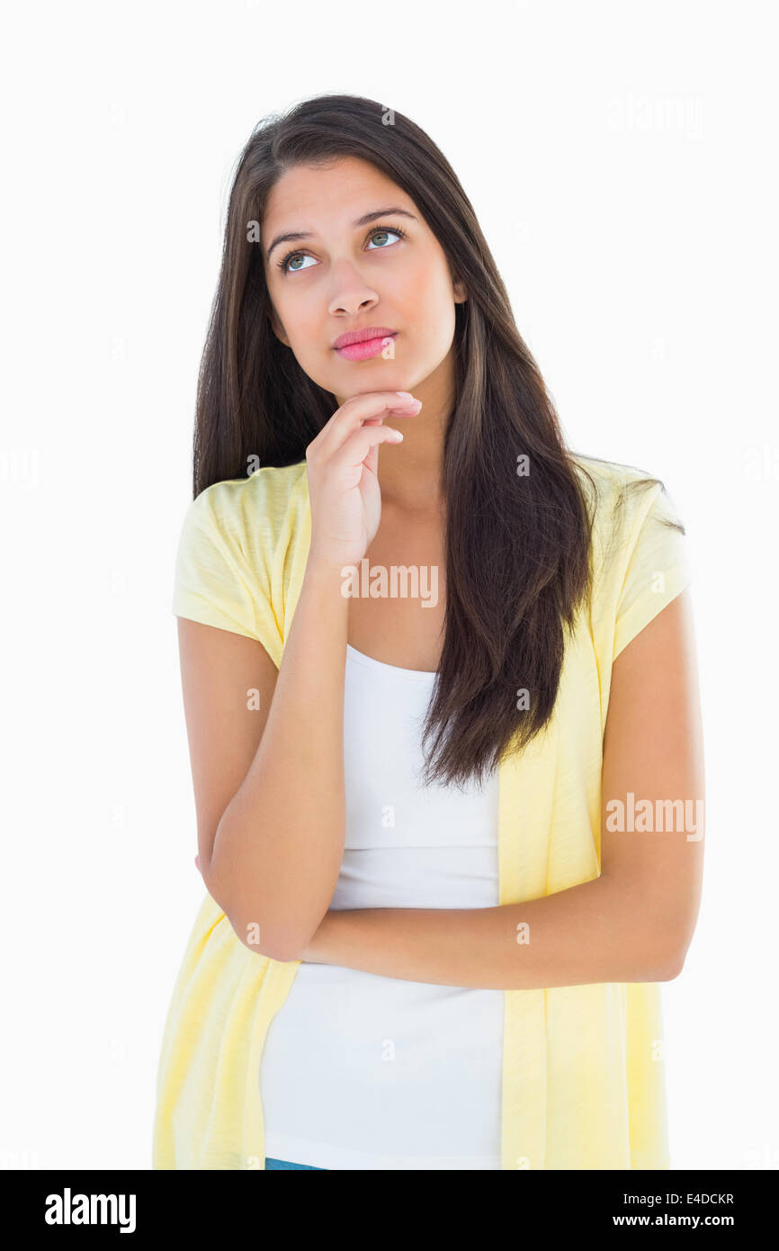 Glückliche lässige Frau denken mit Hand am Kinn Stockfoto