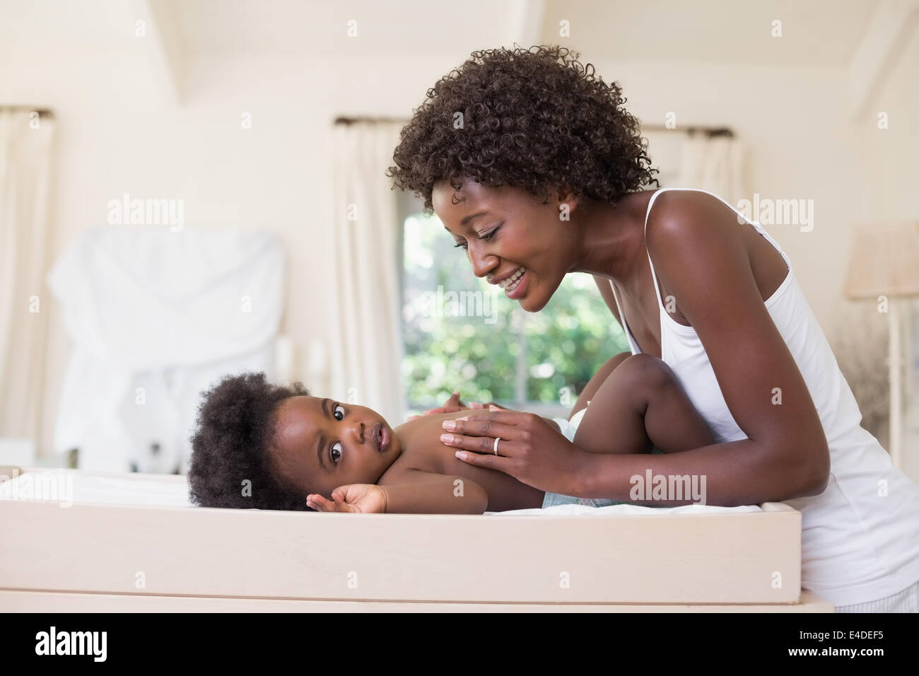 Glückliche Mutter mit Baby Girl am Wickeltisch Stockfoto