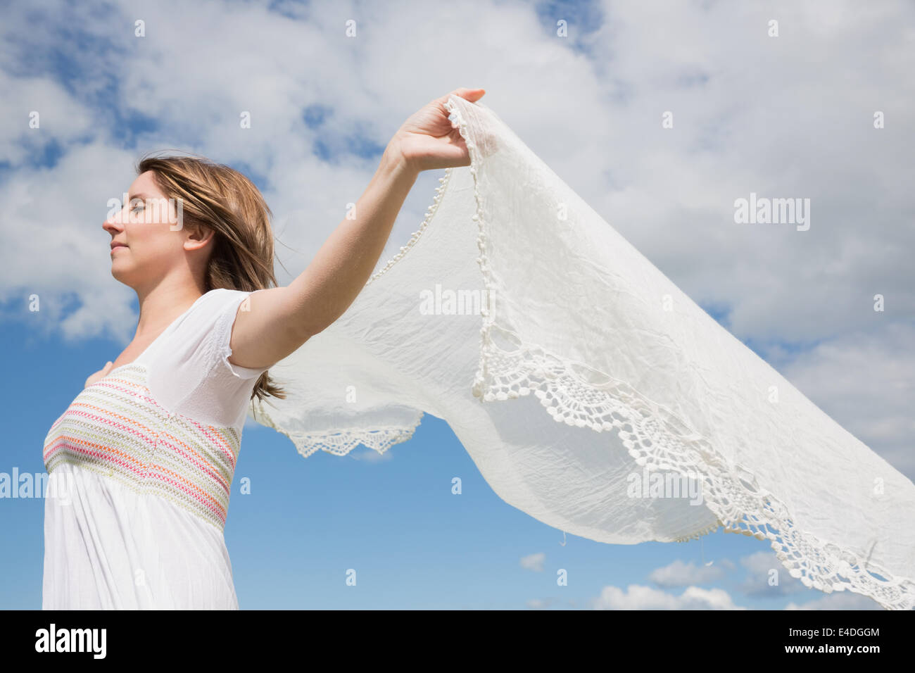 Frau in der Hand aus Schal gegen blauen Himmel und Wolken Stockfoto