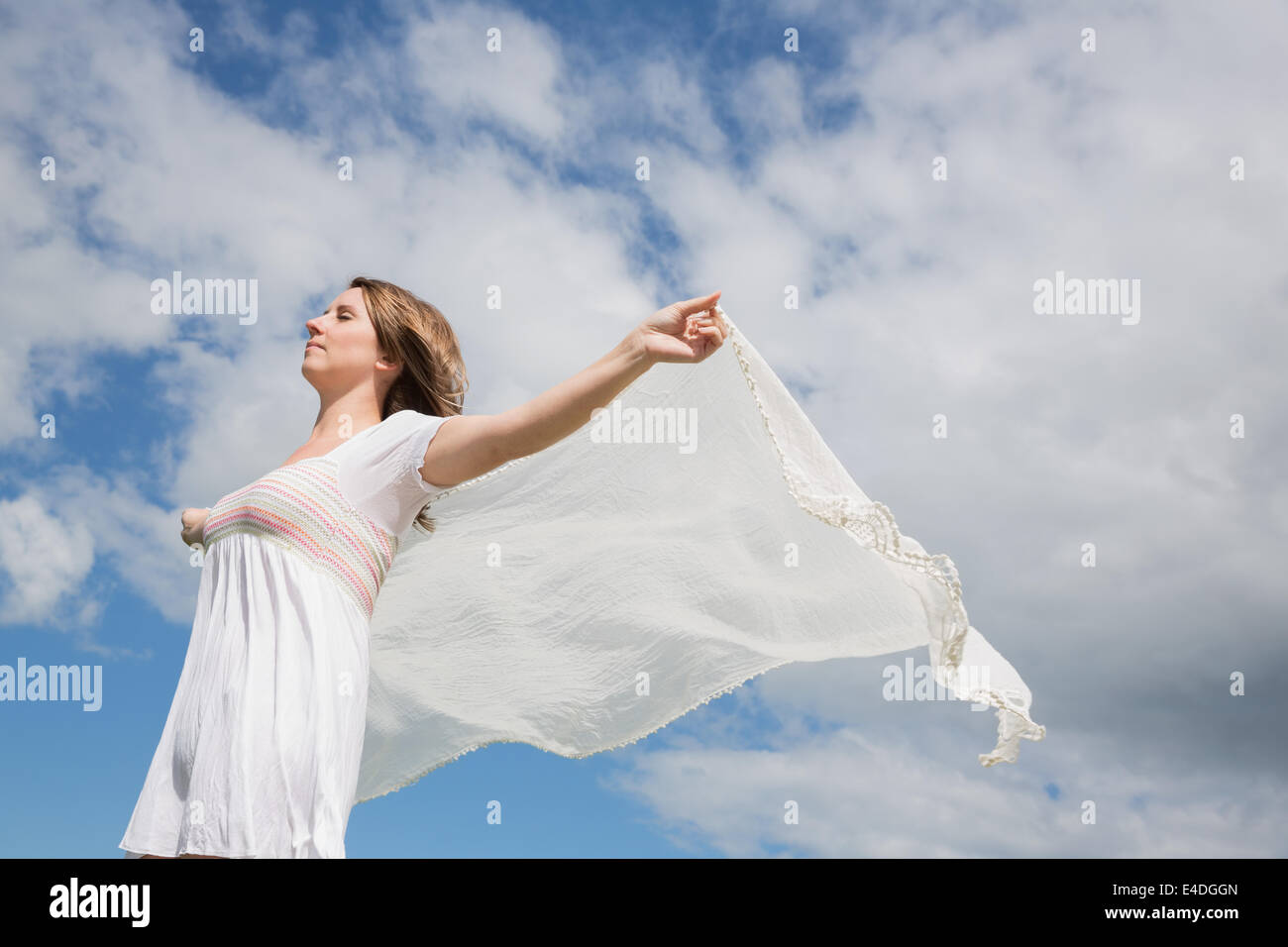 Frau in der Hand aus Schal gegen blauen Himmel und Wolken Stockfoto