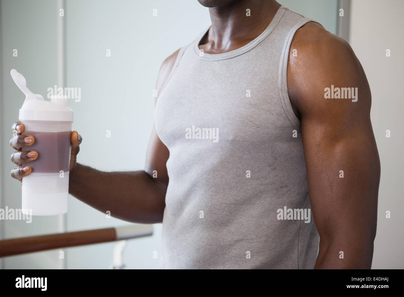 Sportlicher Mann mit Protein Drink im Fitness-Studio Stockfoto