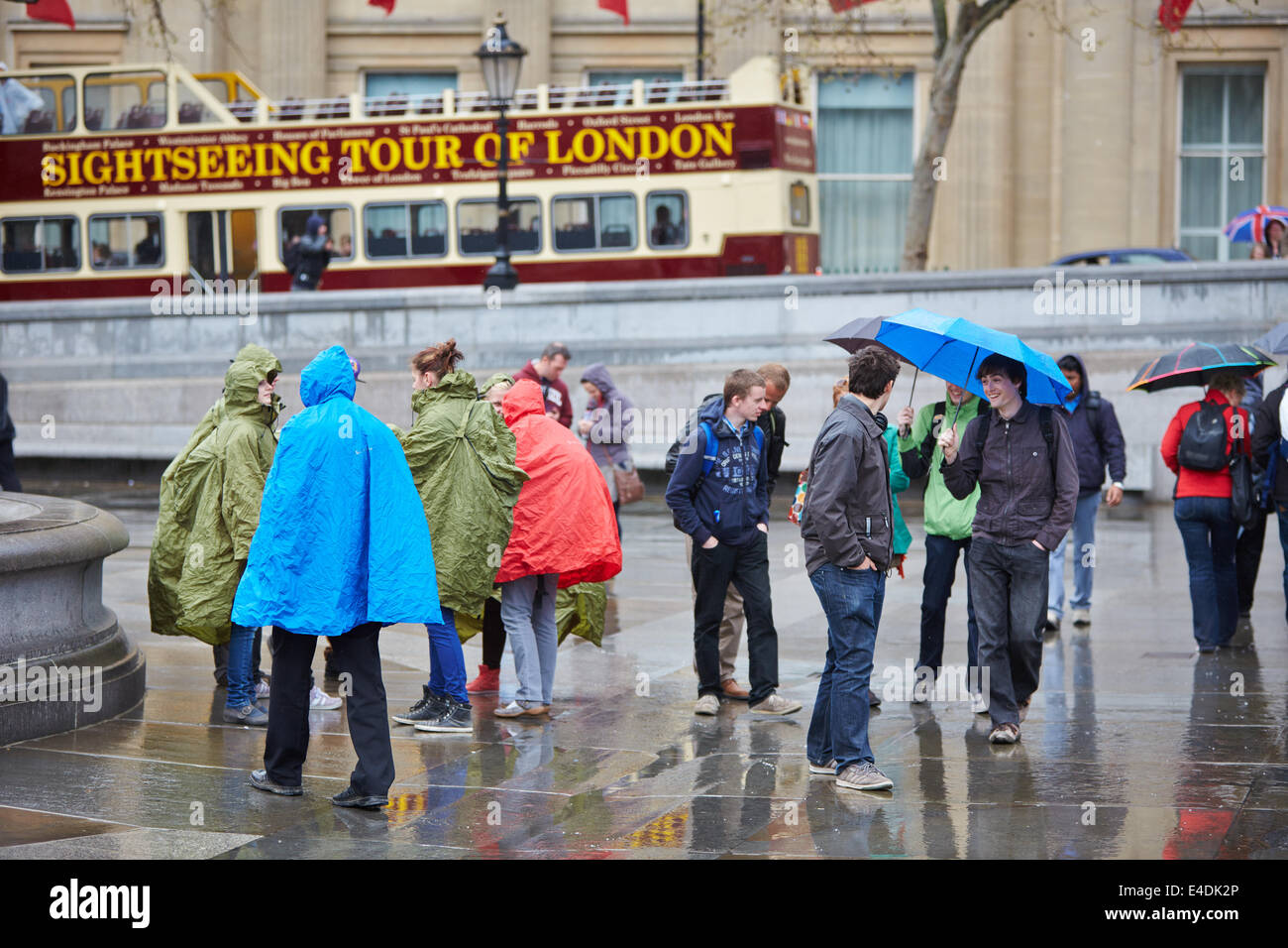 Touristen, die Ponchos tragen zum Schutz vor dem Regen auf dem Trafalgar Square Stockfoto