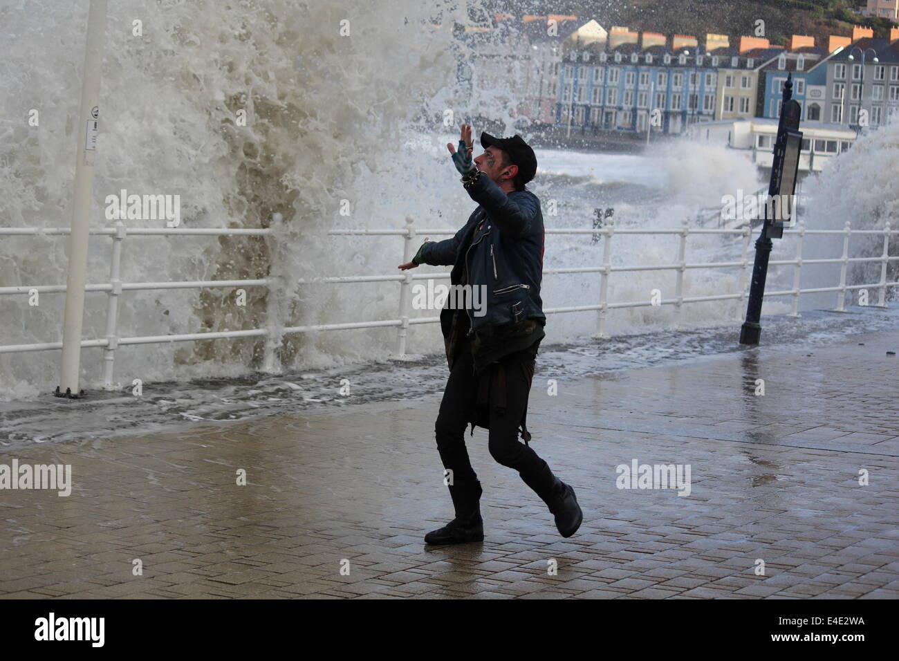 Ein Punk-Stil Mann posiert durch stürmische See auf Aberystwyth promenade Stockfoto
