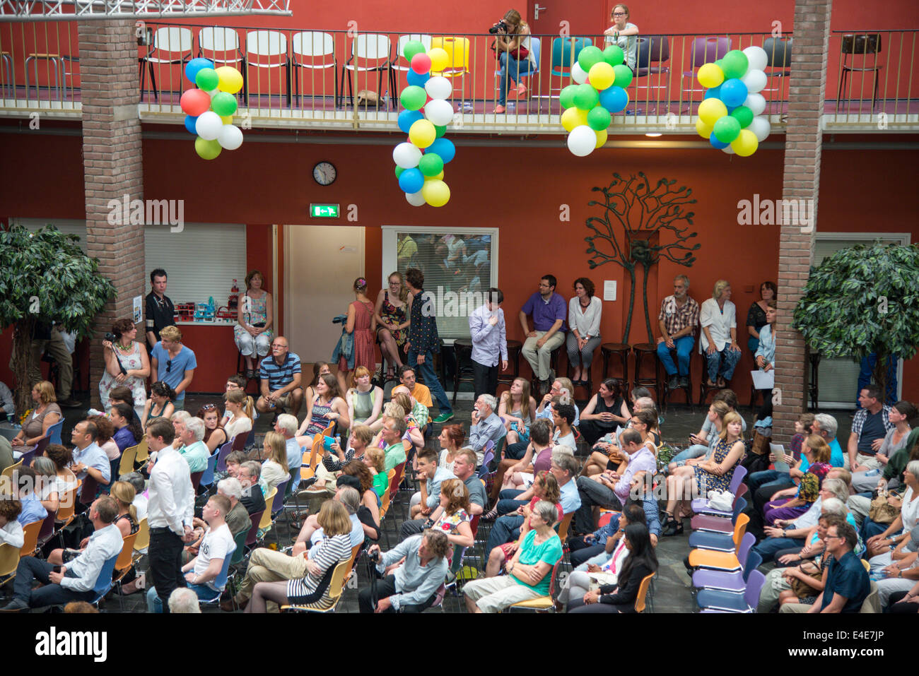 Viele Eltern in einem Gymnasium zusammen, um die Gelehrten zu feiern, die ihre Prüfungen bestanden Stockfoto