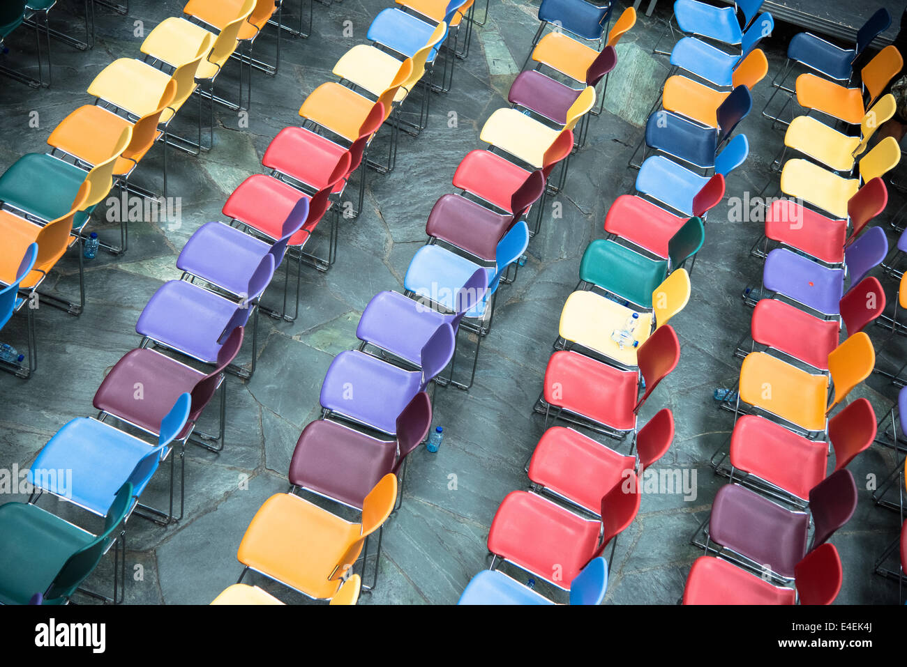 Reihen der bunten und leere Plastikstühle in einer Schule Stockfoto
