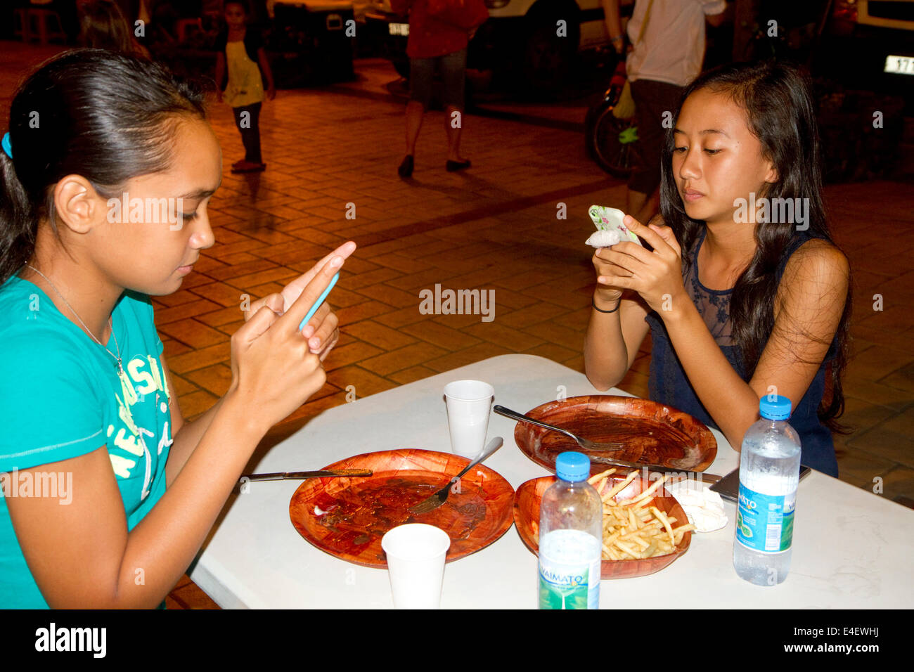 Tahitianische Mädchen im Teenageralter mit Handys auf der Insel Tahiti, Französisch-Polynesien. Stockfoto