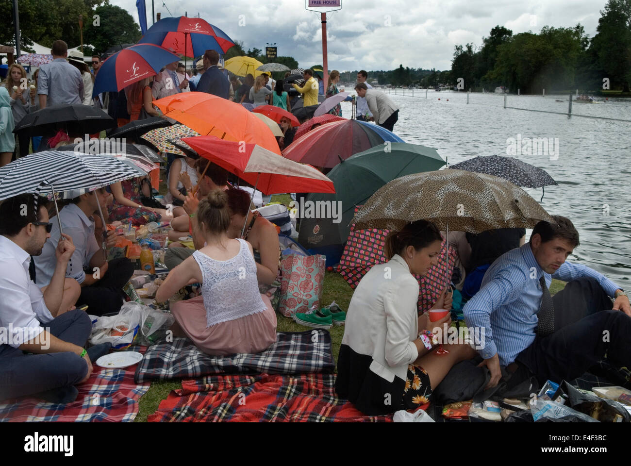 Regen regnet Picknick ein englischer Sommer nasses Wetter 2010er Henley Royal Regatta Massen von Zuschauern säumen die Ufer und schützen ihre Schirme. UK 2014 HOMER SYKES Stockfoto