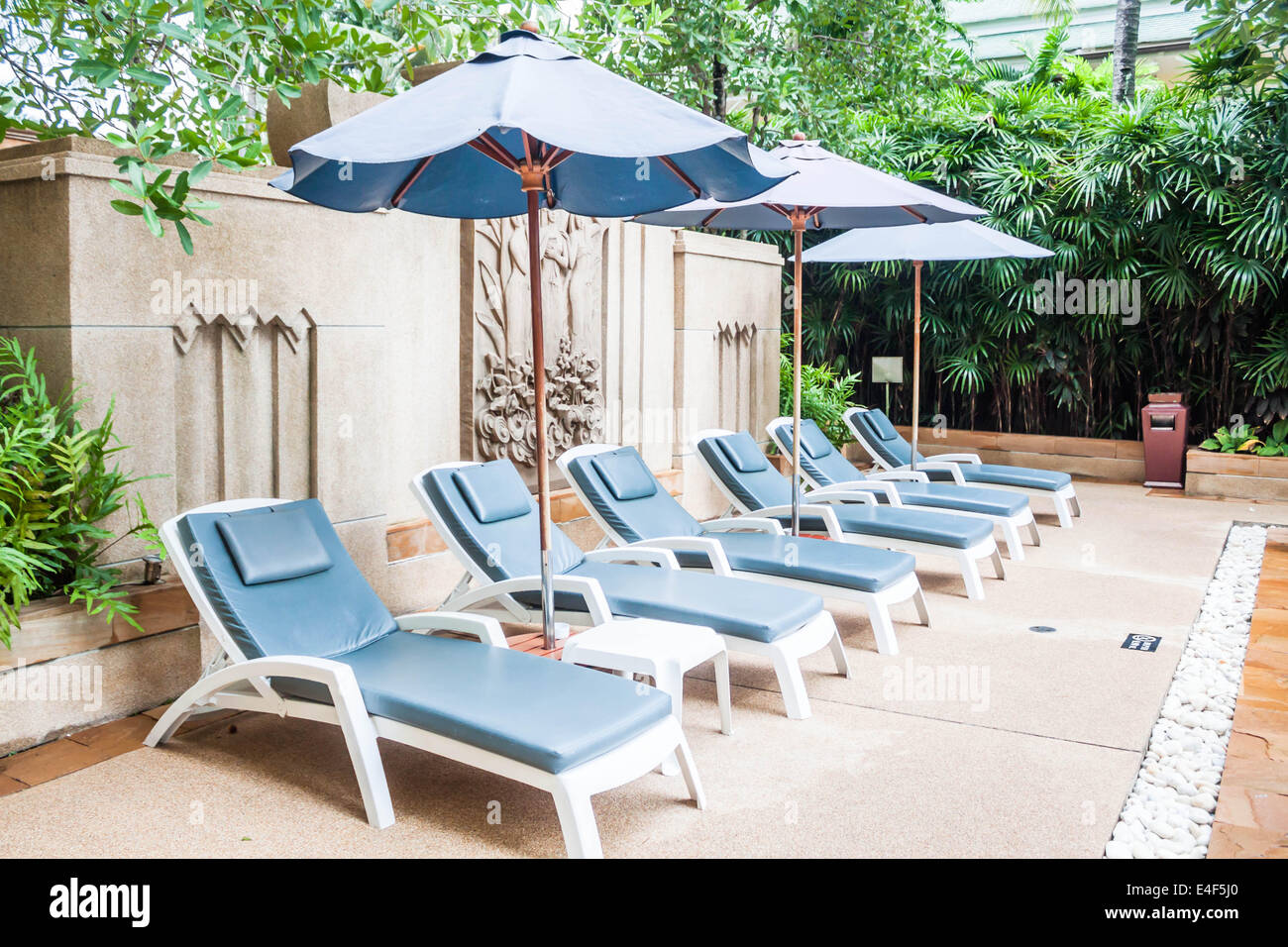 Liegestühle und Sonnenschirme am Swimmingpool des Hotels Stockfoto