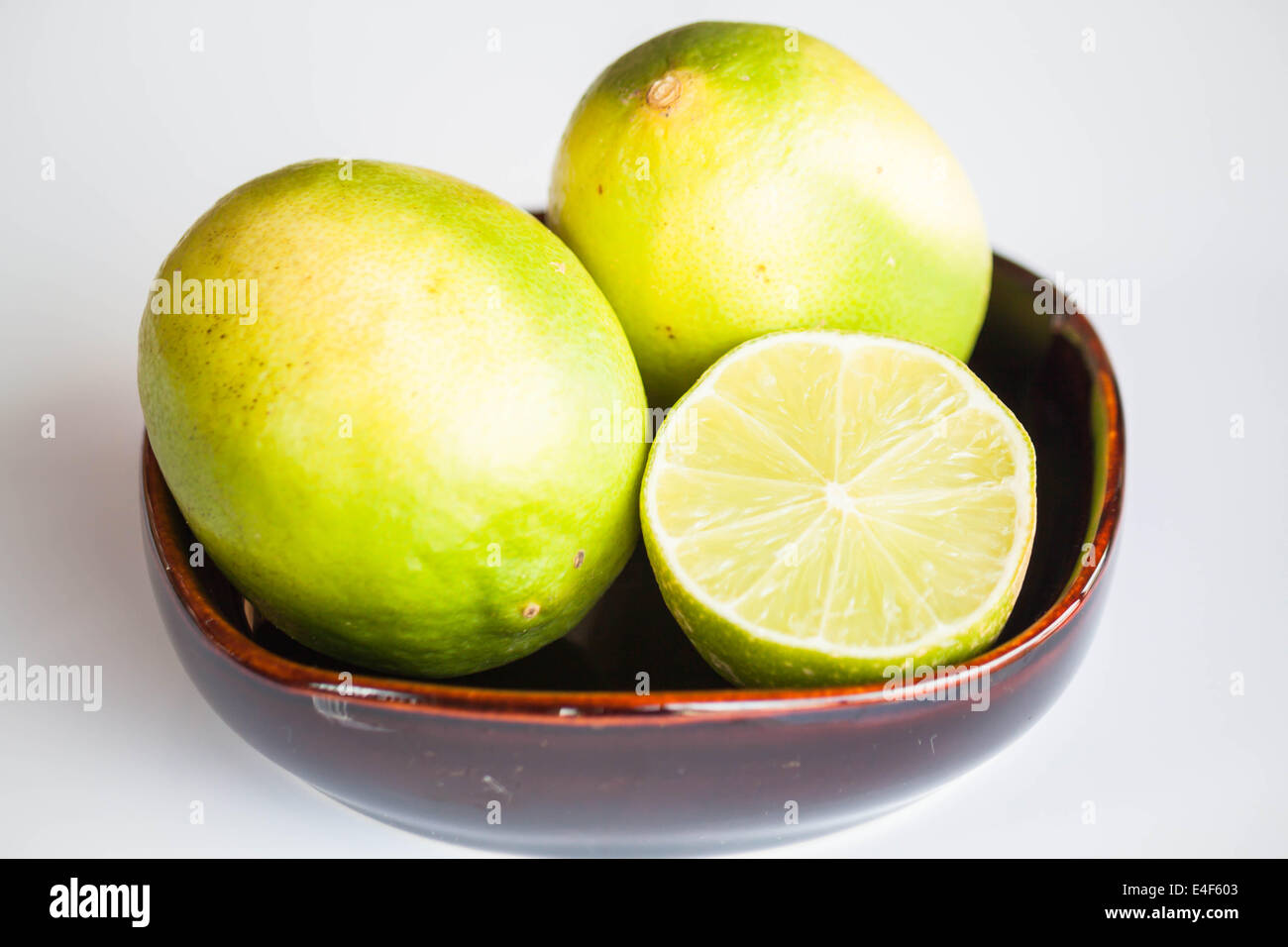 Ganz frische Limetten und Scheibe in Keramikschale Stockfoto