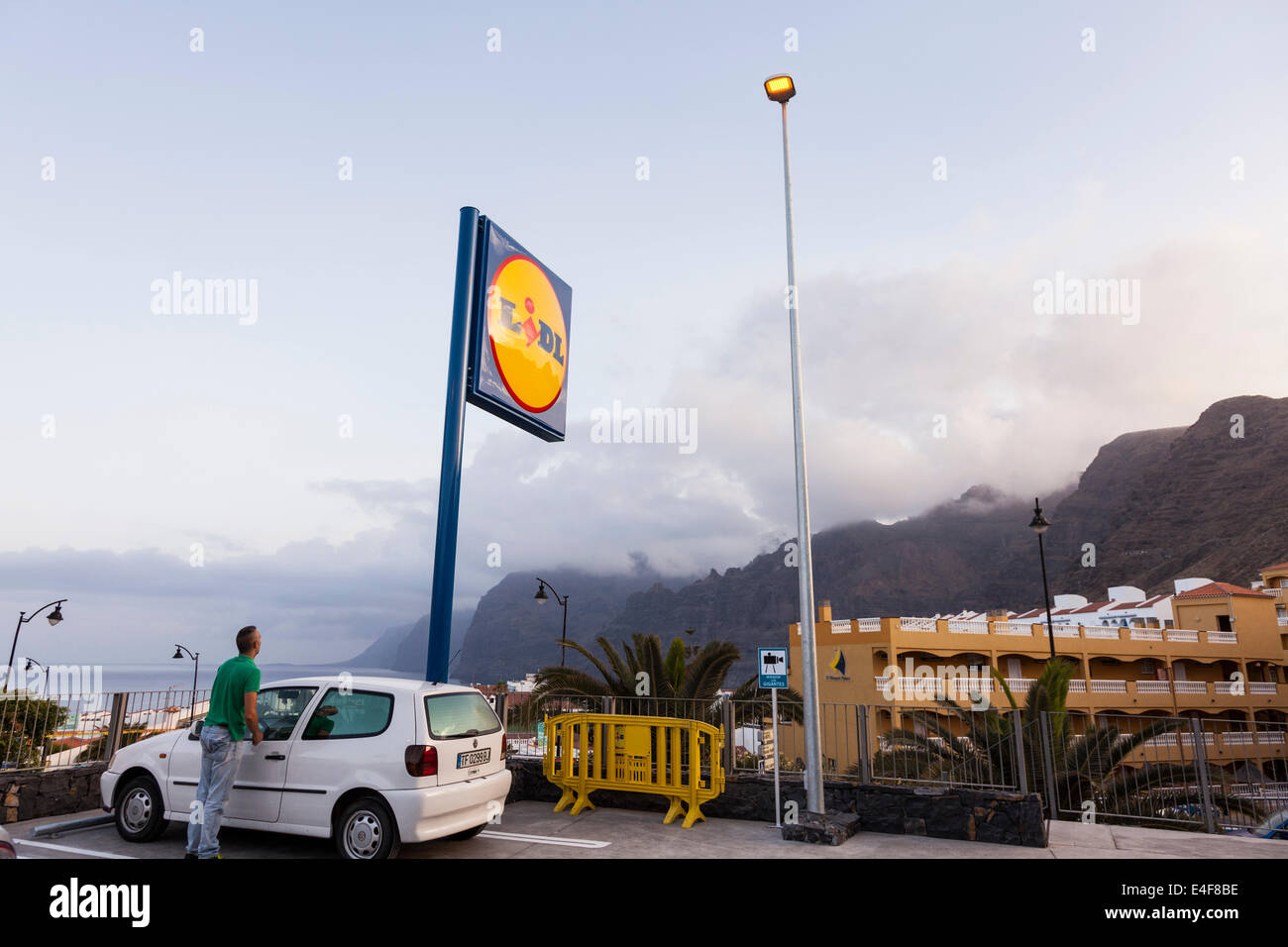 Parkhaus und Lidl-Supermarkt unterzeichnen in Puerto Santiago mit Blick auf die Klippen von Los Gigantes, Teneriffa, Kanarische Inseln, Spanien. Stockfoto