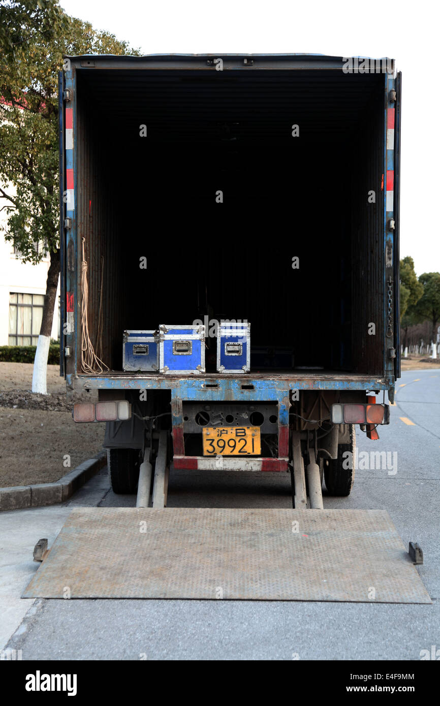 Es ist ein Foto von der Rückseite eines LKW. Es ist offen, aber wir sehen nur innen dunkel. Es gibt nur 3 kleine blaue Kästchen Stockfoto