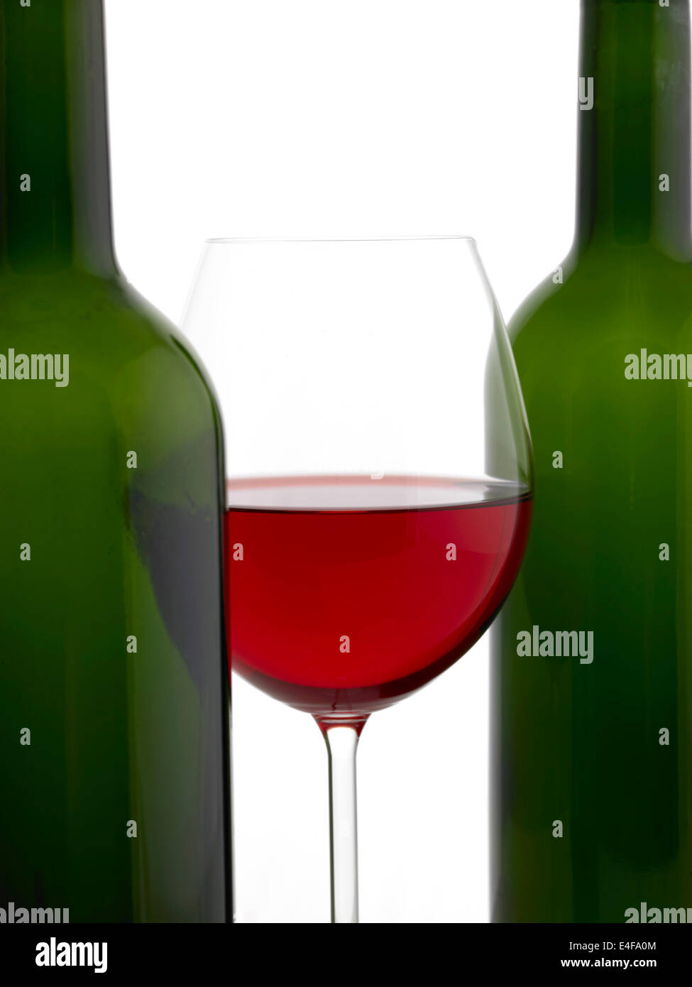 zwei grüne Weinflaschen & Glas Rotwein Stockfoto