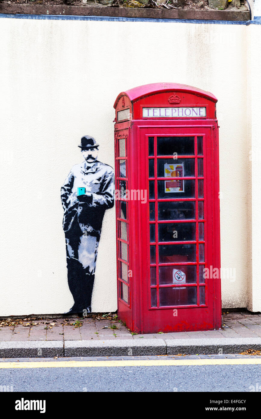Banksy Stil Wandbild Graffiti rote Telefonzelle in Great Malvern Worcestershire UK England Stockfoto