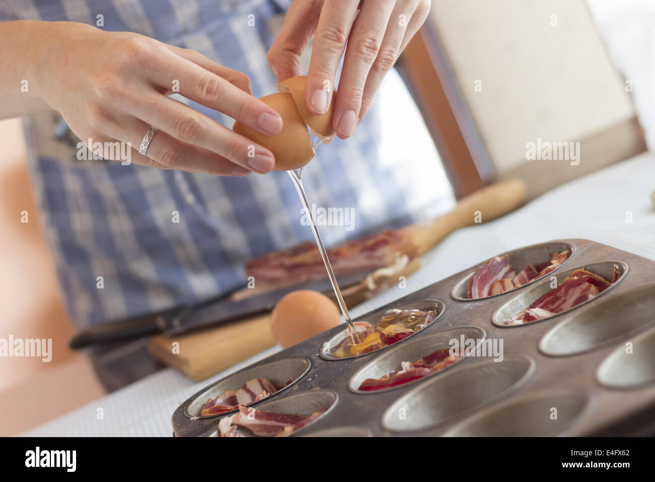 Koch ein Ei in einer Pfanne Muffin knacken Altsteinzeit Muffins zum Frühstück machen Stockfoto