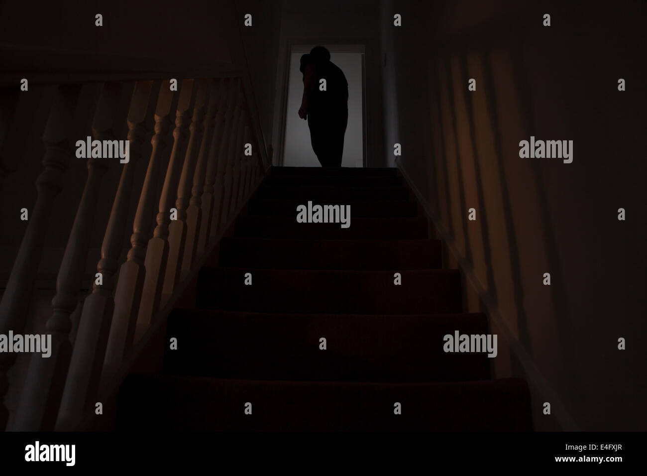 Rückansicht Silhouette eines Mannes Betreten eines Raumes am oberen Rand der Treppe. Stockfoto