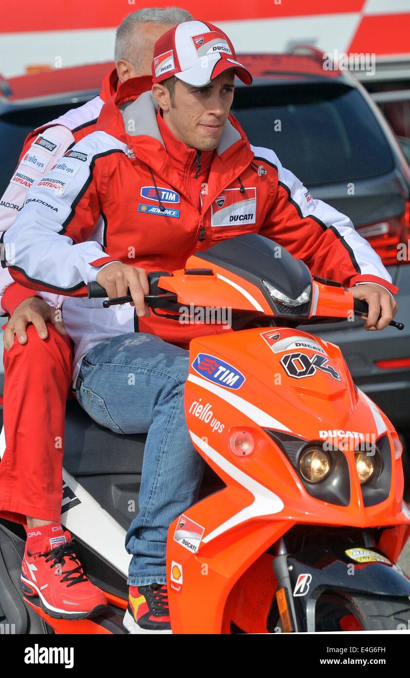 Italienische Ducati Moto GP-Fahrer Andrea Dovizioso (R) fährt einen Roller  zu einer Pressekonferenz auf dem Sachsenring-Rennstrecke in  Hohenstein-Ernstthal, Deutschland, 10. Juli 2014. Den deutschen Grand Prix  der Kategorien Moto3 sowie Moto2 und