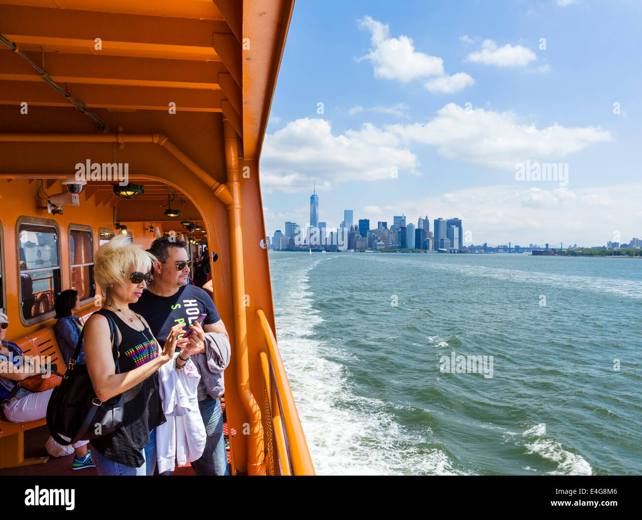 Passagiere an Bord der Fähre nach Staten Island mit der Lower Manhattan Skyline hinter New York City, NY, USA Stockfoto
