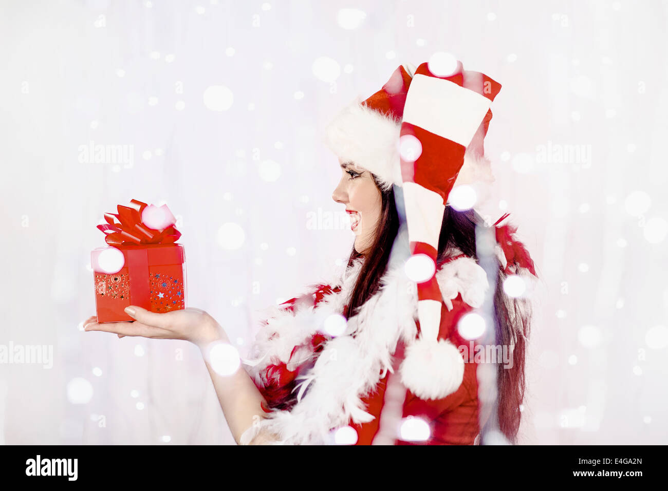 Junge Frau im Weihnachtsmann-Kostüm mit Geschenk-box Stockfoto