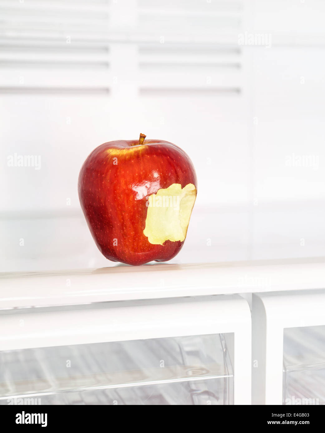 Nahaufnahme Foto des großen roten angebissene Apfel im leeren Kühlschrank, Obst-Diät, gesunde Lebensweise, Bio Ernährung, Gewicht verloren Stockfoto