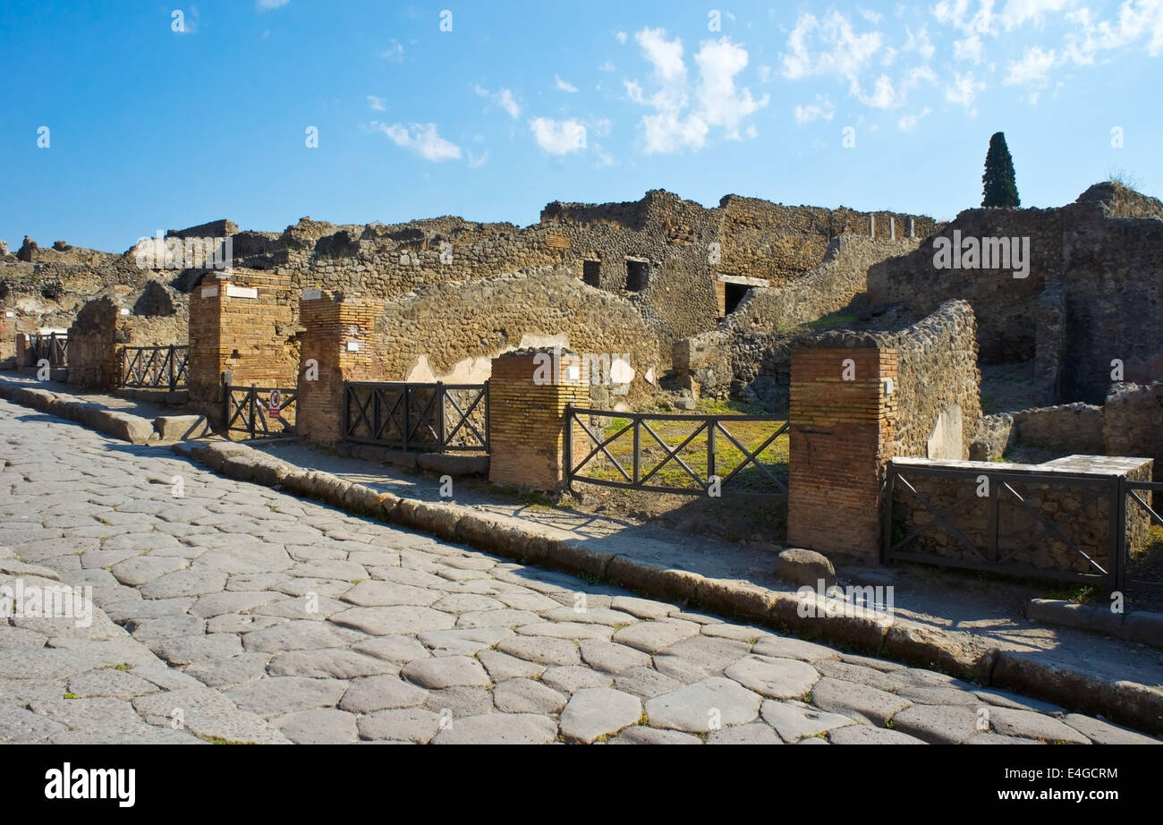 Eine gepflasterte Straße führt durch eine Nachbarschaft von Pompeji Stockfoto