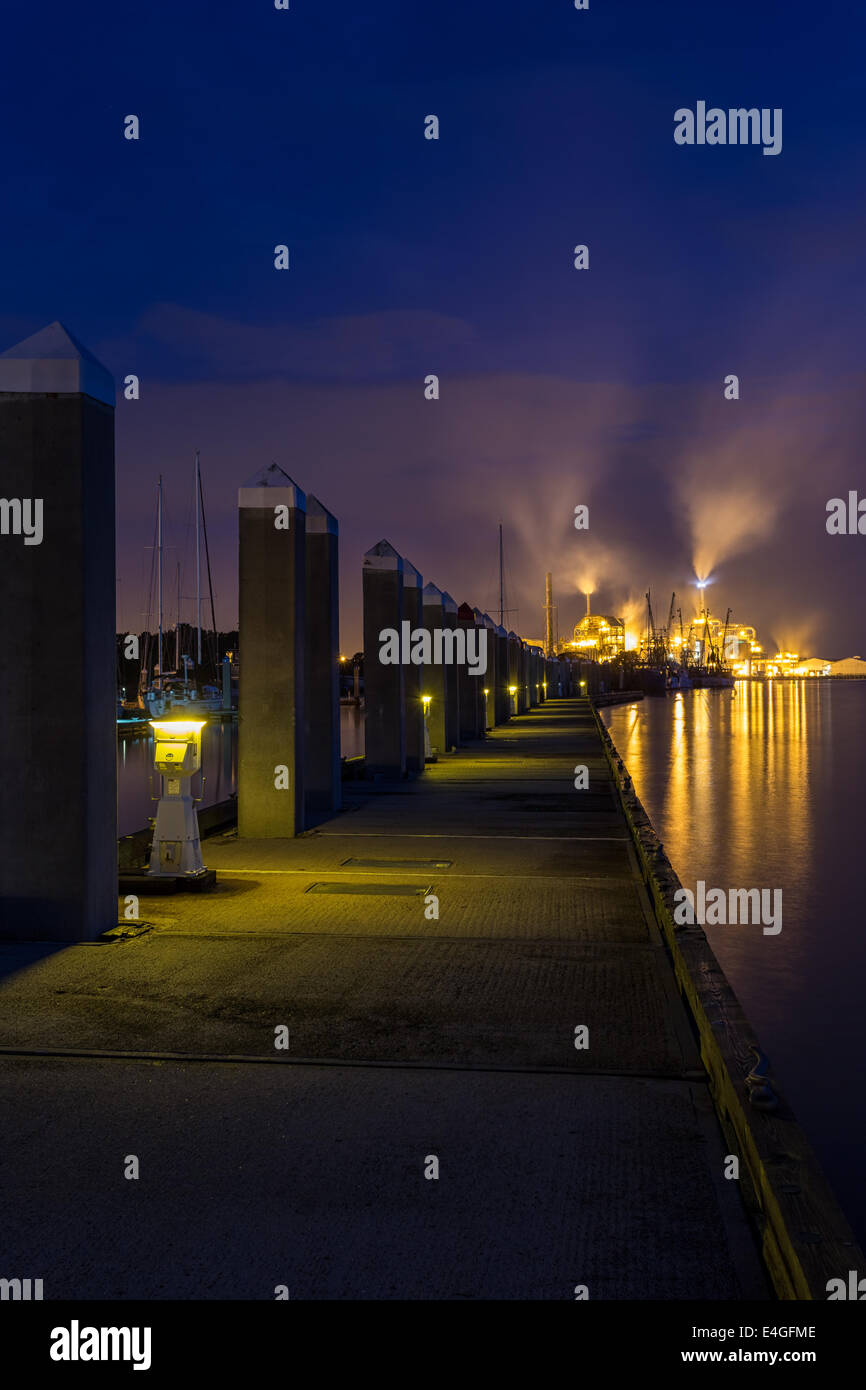 Schöne Nachtszene von einem Dock an der Fernandina Beach Marina führt zu den beleuchteten Rayonier Zellstoffwerk im Hintergrund. Stockfoto