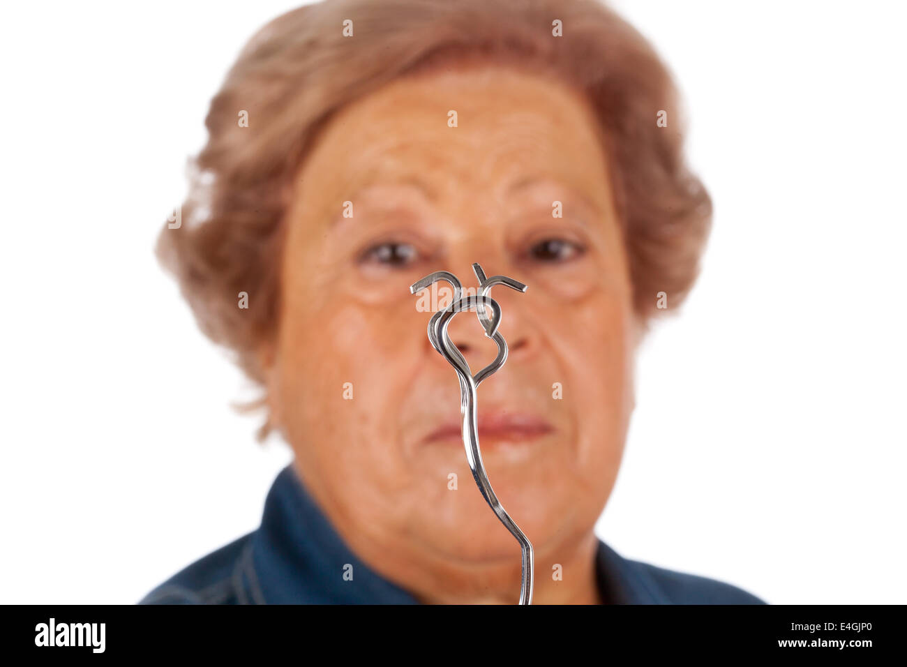 Ältere Frau mit psychokinetischen Fähigkeiten biegen Metall Gabel. Stockfoto