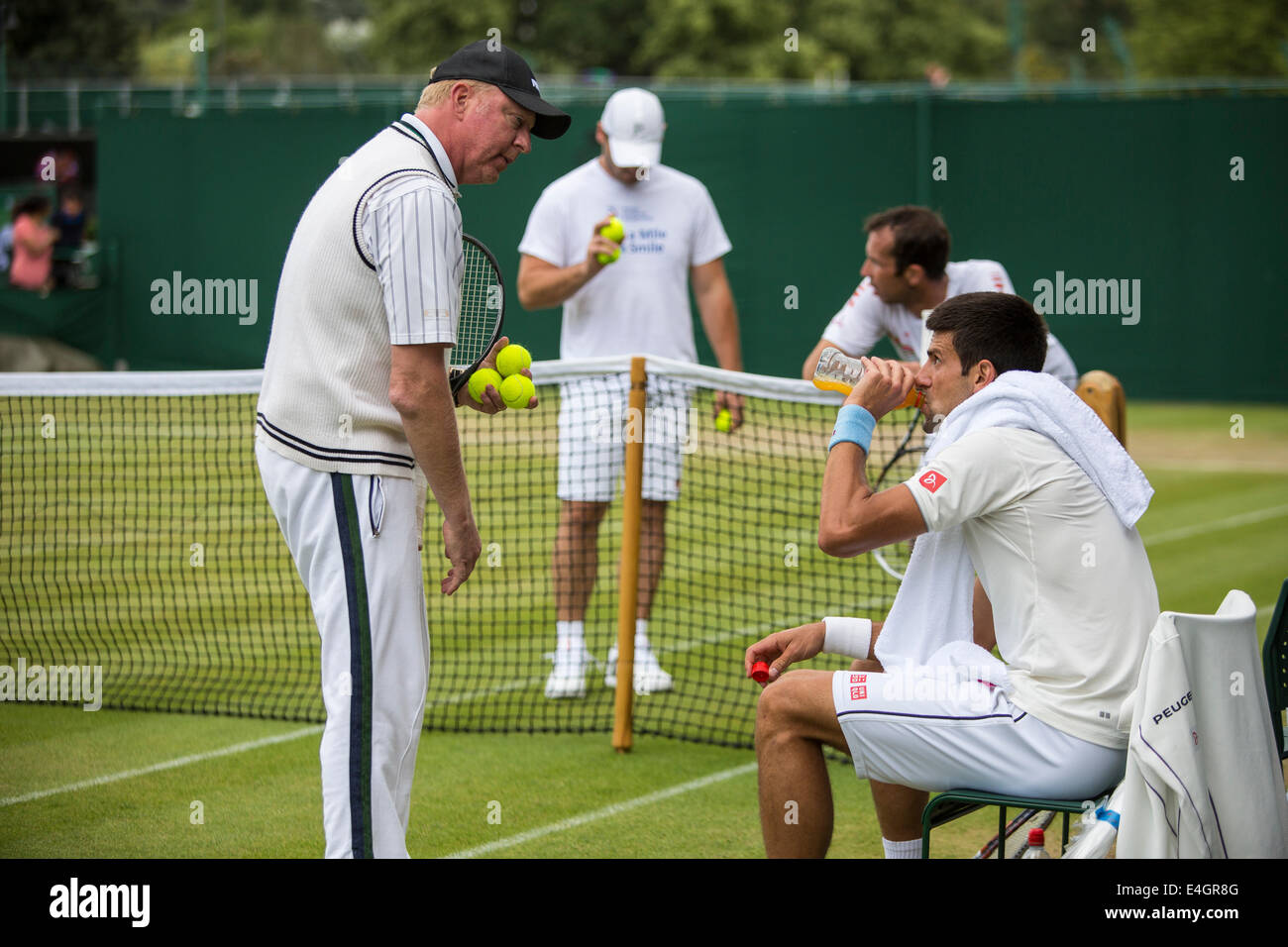 Boris Becker links () Trainer Novak Djokovic (rechts), wie er auf Court Nr. 4 The Championships Wimbledon 2014 die alle Engla praktiziert Stockfoto