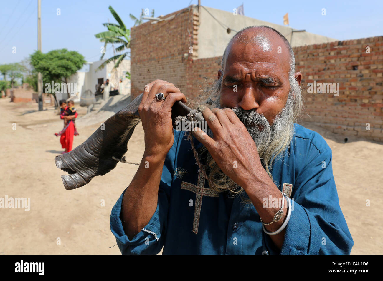 Mann bläst auf einem Ziegen-Horn, Khushpur Dorf, Punjab, Pakistan Stockfoto
