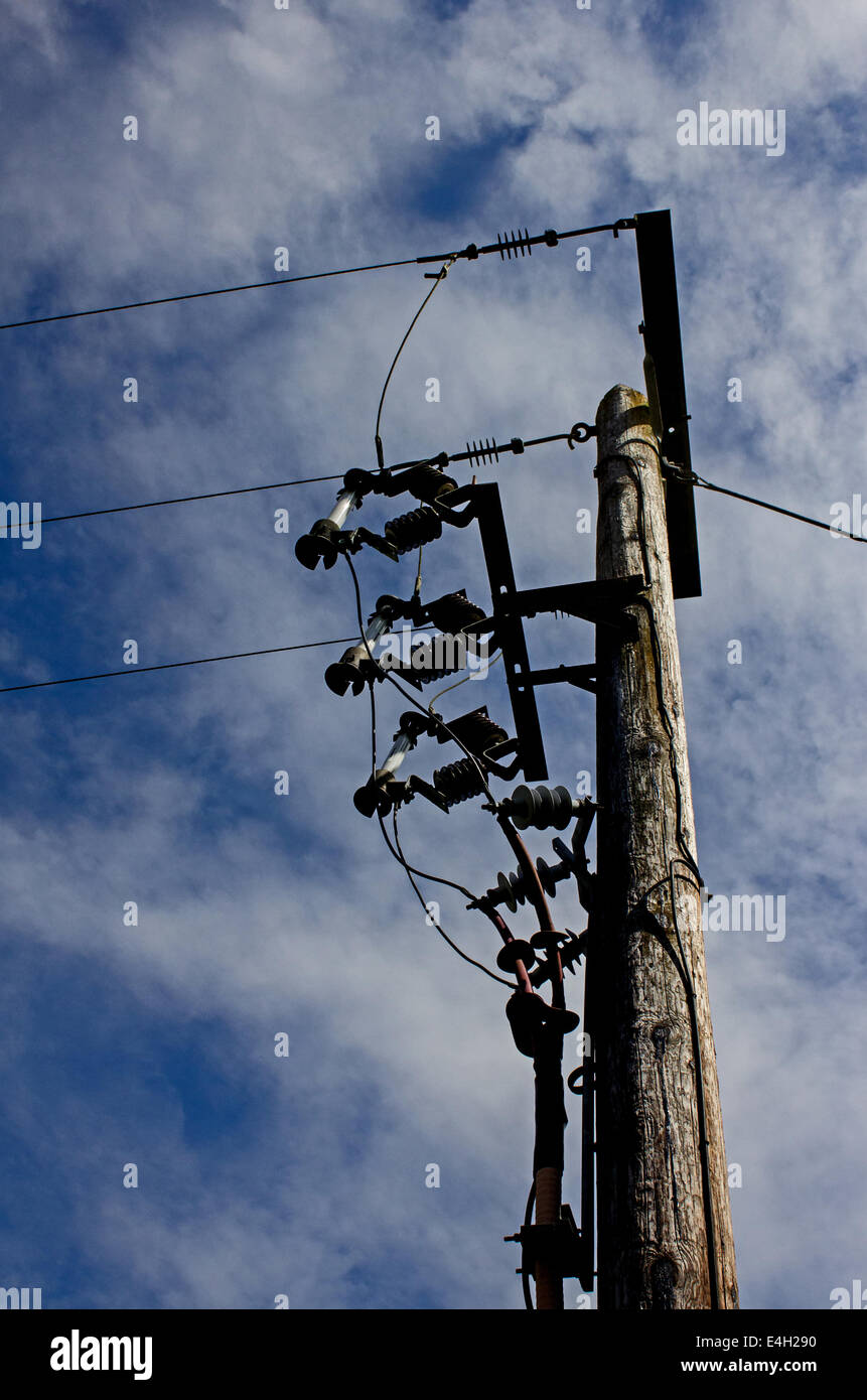 Holzstange mit Stromkabel gegen blau und bewölktem Himmel Stockfoto