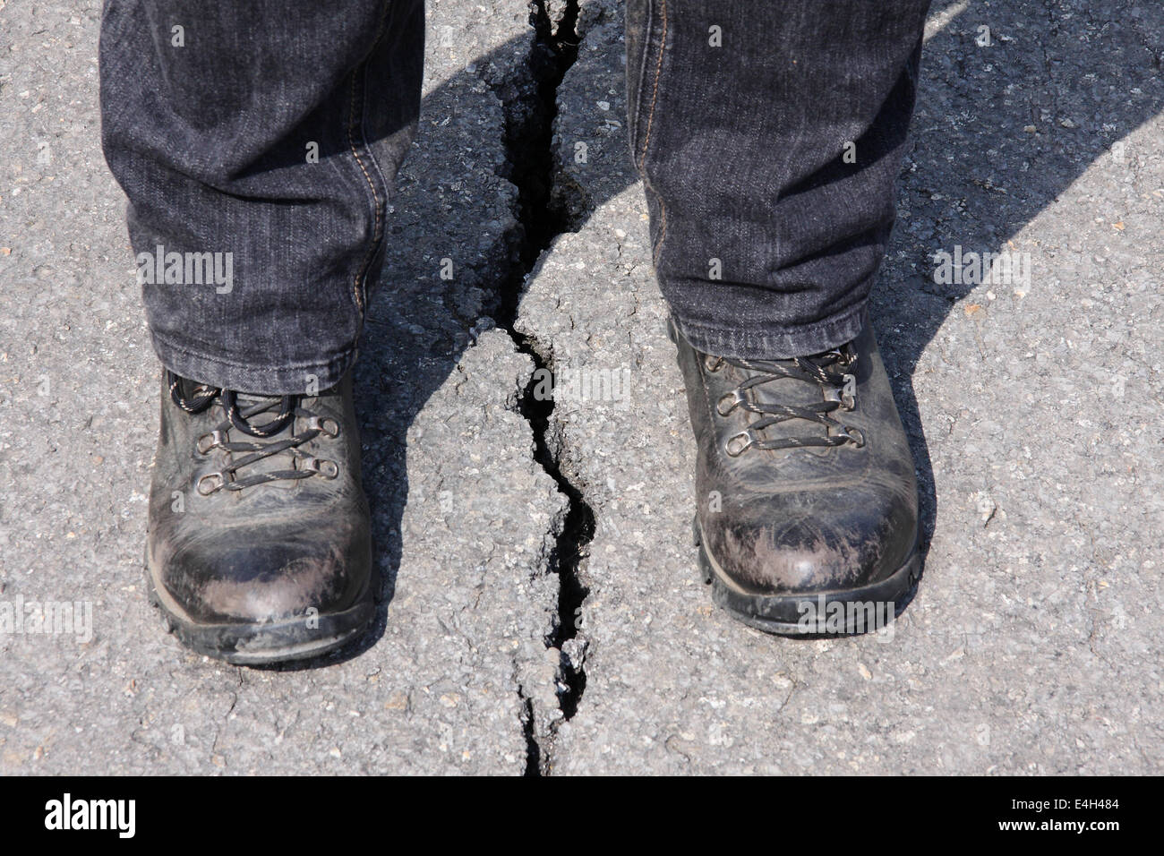 Eine Person steht über einen Riss verursacht durch einen Erdrutsch auf ...
