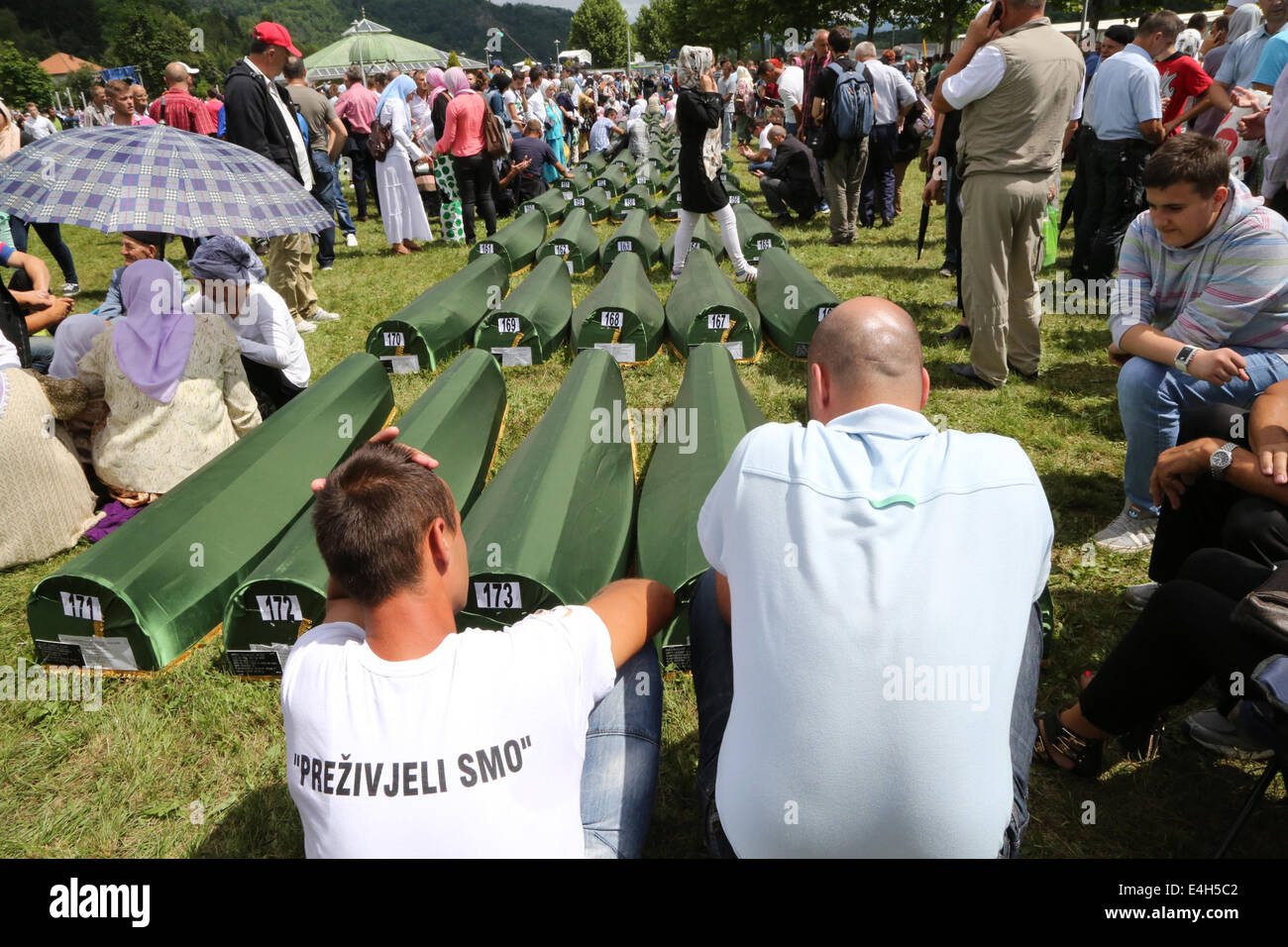 (140712)--SREBRENICA, 12. Juli 2014 (Xinhua)--Verwandten sitzen neben trauern Särge der Opfer vor einer Beerdigung in Potocari, in der Nähe von Srebrenica, Bosnien und Herzegowina, 11. Juli 2014. Freitag fand die Beerdigung von 175 neu identifizierte Opfer hier des 19. Jahrestags des Massakers von Srebrenica. Rund 7.000 muslimische Männer und jungen wurden massakriert und in der Nähe von Srebrenica von bosnisch-serbischen Truppen im Juli 1995, das schlimmste Massaker in Europa seit dem Ende des zweiten Weltkriegs. (Xinhua/Haris Memija) (Zjl) Stockfoto