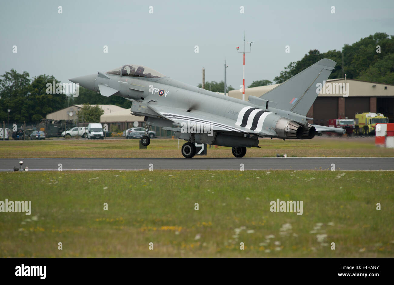 RAF Fairford, Gloucestershire UK. 11. Juli 2014. Eurofighter Typhoon FGR4 von RAF Coningsby komplett mit D-Day Invasion Streifen kommt für eine Anzeige auf den ersten Tag der RIAT. Die State-of-the-Art-Jet wurde speziell mit den berühmten schwarzen und weißen Markierungen in Hommage an die Rolle der Besatzungen die Hawker Typhoon während der d-Day Operation gemalt. Bildnachweis: Malcolm Park Leitartikel/Alamy Live-Nachrichten Stockfoto