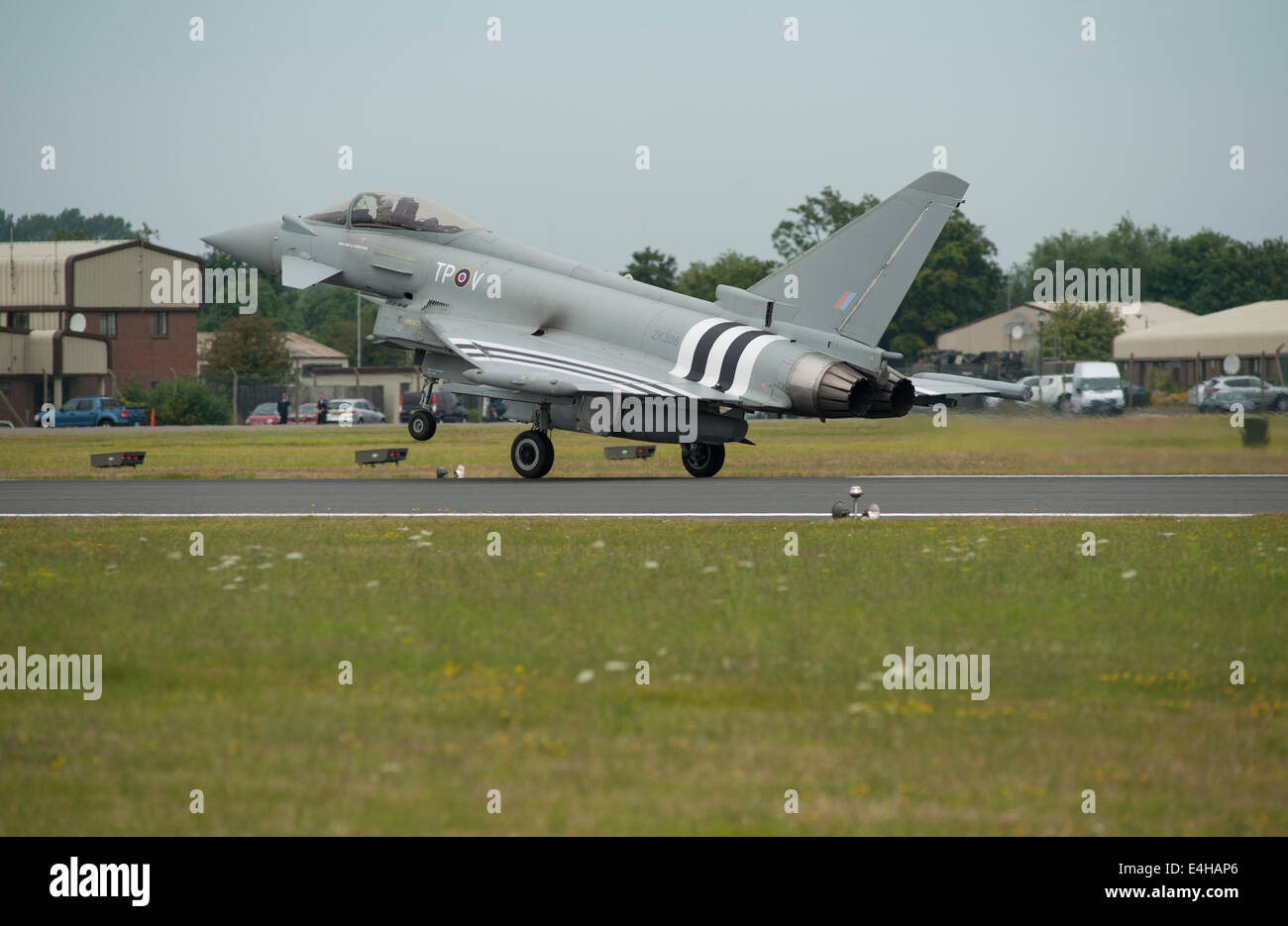 RAF Fairford, Gloucestershire UK. 11. Juli 2014. Eurofighter Typhoon FGR4 von RAF Coningsby komplett mit D-Day Invasion Streifen kommt für eine Anzeige auf den ersten Tag der RIAT. Die State-of-the-Art-Jet wurde speziell mit den berühmten schwarzen und weißen Markierungen in Hommage an die Rolle der Besatzungen die Hawker Typhoon während der d-Day Operation gemalt. Bildnachweis: Malcolm Park Leitartikel/Alamy Live-Nachrichten Stockfoto