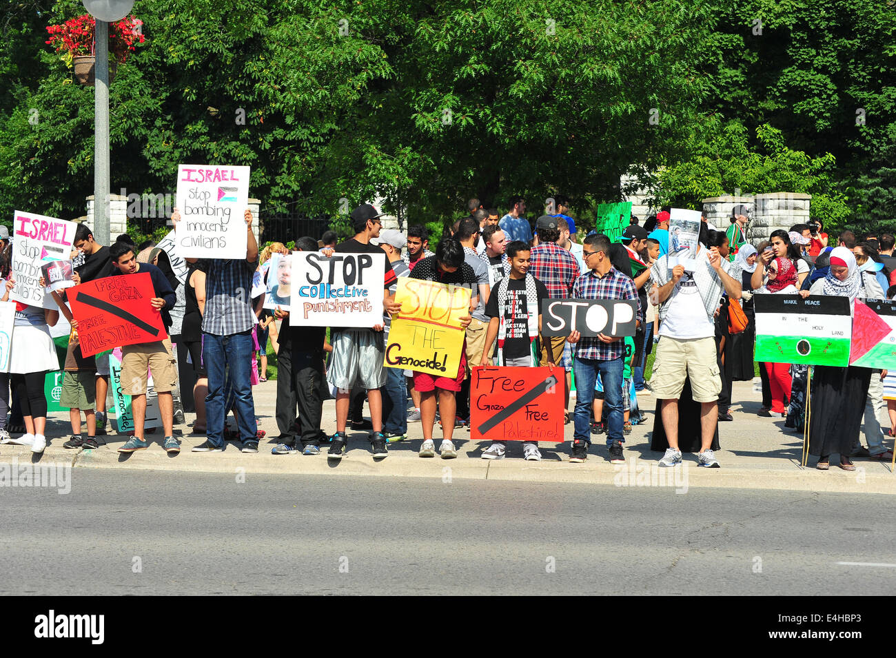 Menschen schwenkten palästinensische Fahnen und halten Plakate Protest gegen die israelischen Angriffe auf Gaza. Stockfoto