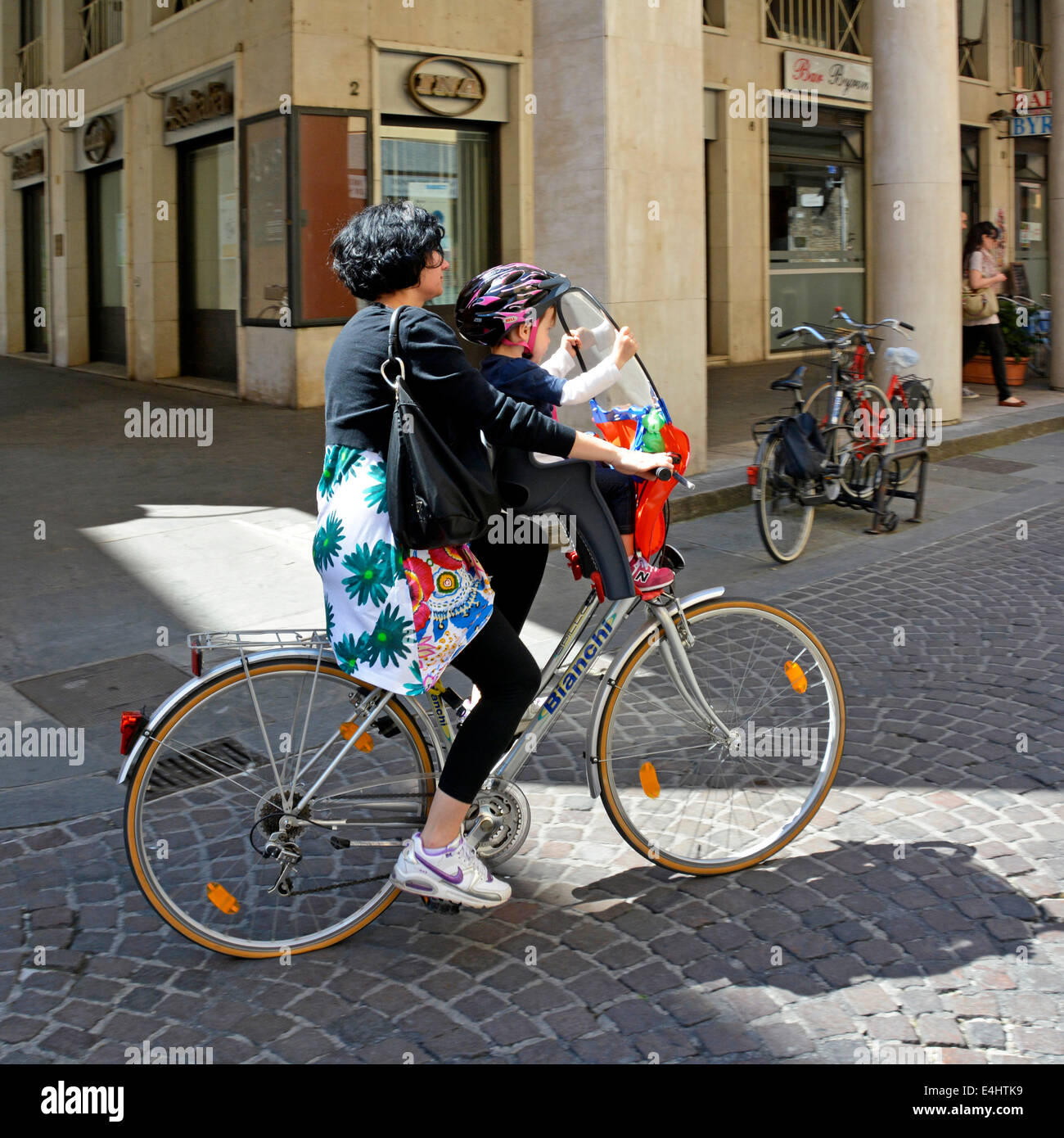 Frau (Mutter?) mit dem Fahrrad mit Kind sitzen halten Windschutzscheibe und  mit Bell Helm Stockfotografie - Alamy