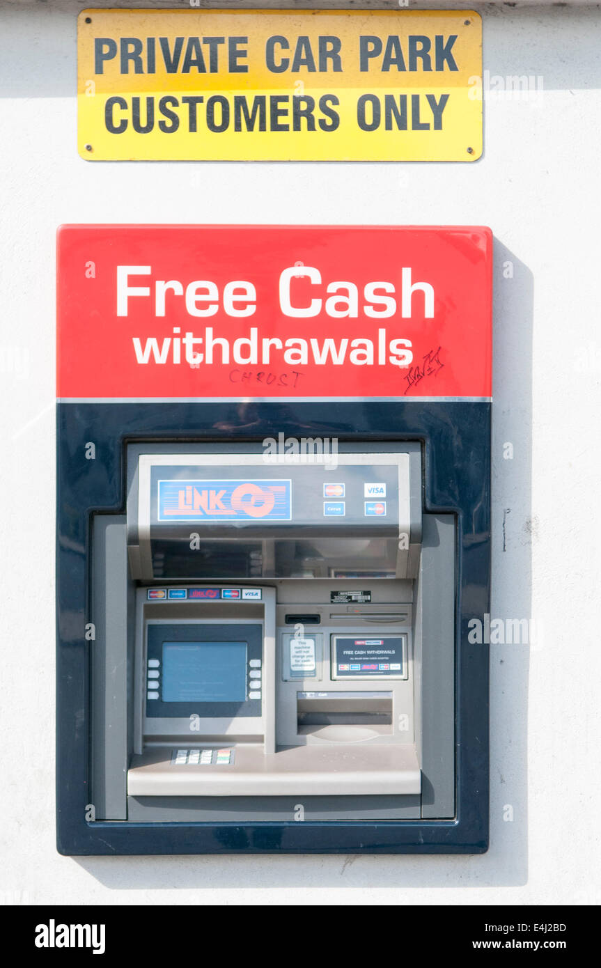 Geldautomat kostenlos Bargeld abheben und ein Zeichen oben sagen "Privatparkplatz, Kunden nur" geben Stockfoto