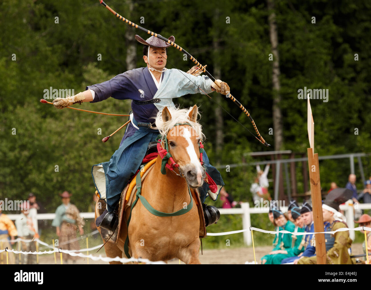 Reiten Samurai treibt sein Pferd in der traditionellen japanischen Yabusame-Zeremonie des berittenen Bogenschießens in Helsinki durchgeführt. Stockfoto