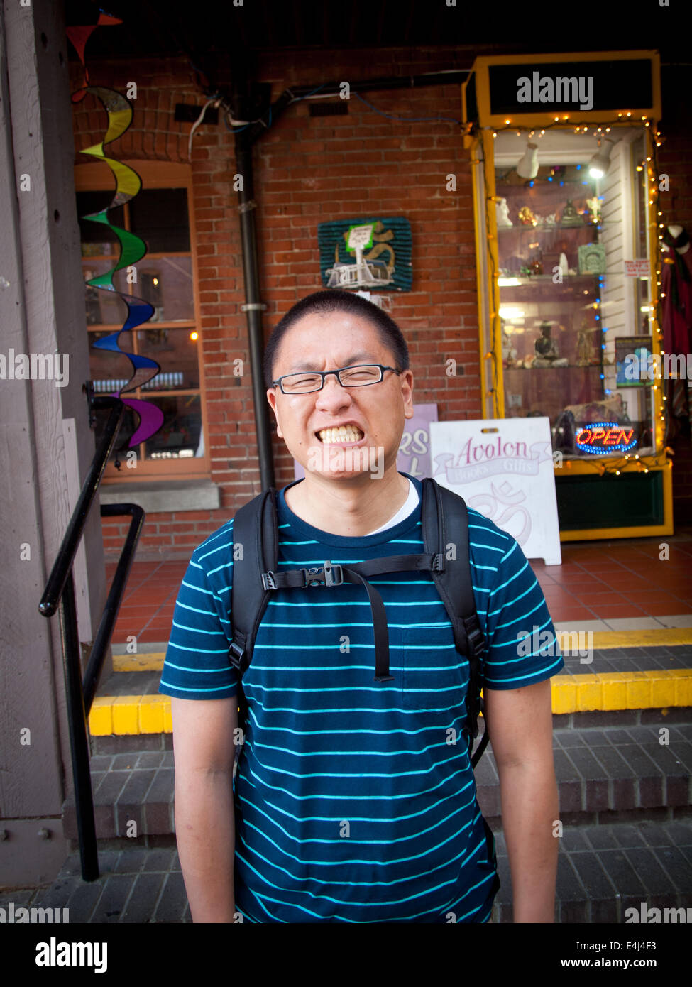 Ein asiatischer Mann Grimassen.  Marktplatz, Victoria, Britisch-Kolumbien, Kanada. Modell-Version auf Anfrage erhältlich. Stockfoto