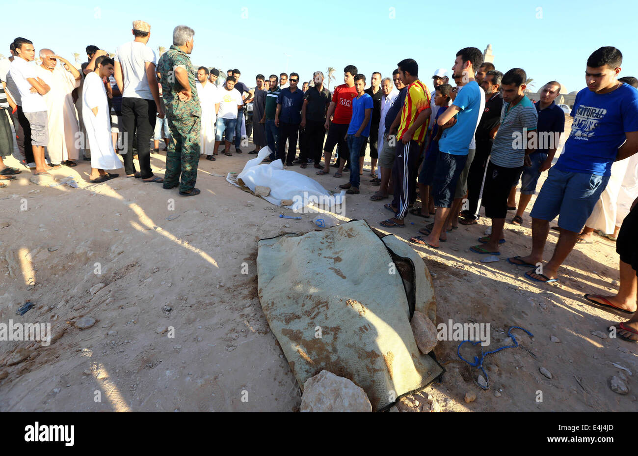 Tripoli, Libyen. 12. Juli 2014. Lokale Leute betrachten einen Körper eines illegalen Einwanderers an der Küste in der Nähe von Tripolis, Libyen, am 12. Juli 2014. Insgesamt 12 Körper illegaler Einwanderer fanden sich vor der Küste in der Nähe von Libyens Hauptstadt Stadt von Tripoli, berichtete die offizielle Agentur von LANA am Samstag. Bildnachweis: Hamza Türkei/Xinhua/Alamy Live-Nachrichten Stockfoto