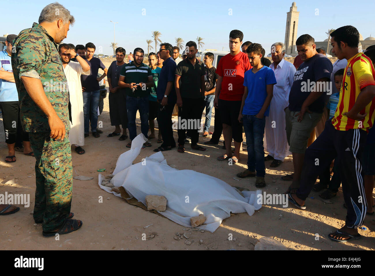Tripoli, Libyen. 12. Juli 2014. Lokale Leute betrachten einen Körper eines illegalen Einwanderers an der Küste in der Nähe von Tripolis, Libyen, am 12. Juli 2014. Insgesamt 12 Körper illegaler Einwanderer fanden sich vor der Küste in der Nähe von Libyens Hauptstadt Stadt von Tripoli, berichtete die offizielle Agentur von LANA am Samstag. Bildnachweis: Hamza Türkei/Xinhua/Alamy Live-Nachrichten Stockfoto