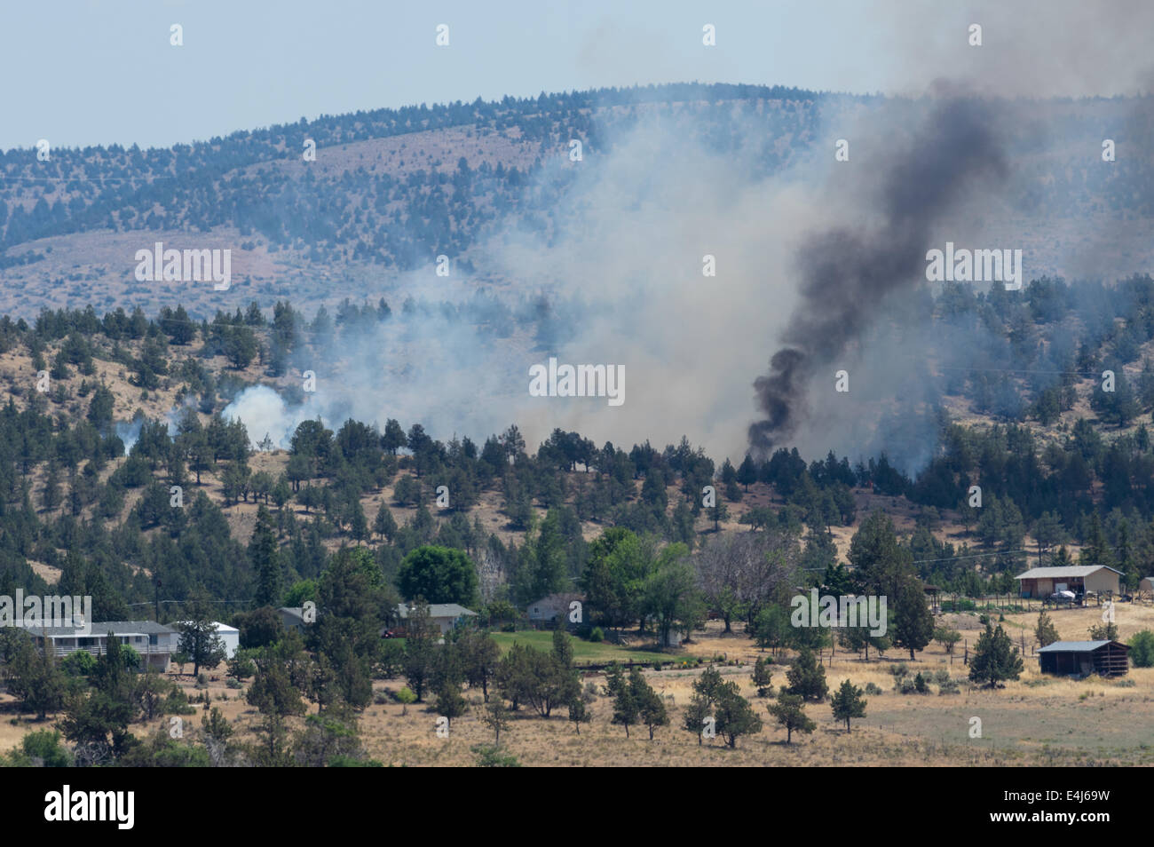 MADRAS, OREGON, 12. April 2014. Ein Lauffeuer bricht in Flamme in der Nähe von Häusern und Nebengebäuden vor den Toren der Stadt von Madras, Oregon in Zentral-Oregon. Stockfoto