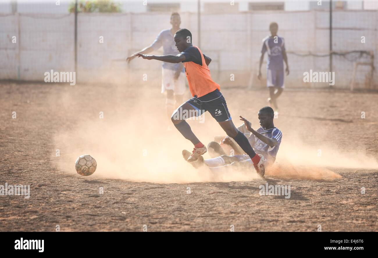 Dakar, Senegal. 10. Juli 2014. Fußballer der Sport 4 Nächstenliebe konkurrieren mit jungen Mitgliedern der örtlichen Fußballverein in einem Freundschaftsspiel in Dakar, der Hauptstadt des Senegal, 10. Juli 2014. Sport 4 Charity wurde vom senegalesischen wählte Spieler Salif Diao armen Jugendlichen aus Afrika eine Chance haben, einen Zugang zu Bildung und Sport helfen gegründet. Die jungen Spieler verfügen über Mittel und Einrichtungen und Möglichkeiten, europäische oder amerikanische Footall Mannschaften zu dienen, nachdem sie ihre Ausbildungen abgeschlossen haben. © Li Jing/Xinhua/Alamy Live-Nachrichten Stockfoto