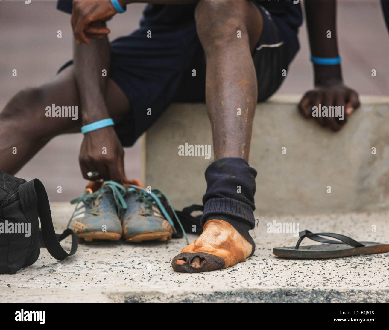 Dakar, Senegal. 9. Juli 2014. Ein Fußballspieler der Sport 4 Nächstenliebe ändert seine Schuhe nach einer Trainingseinheit in Dakar, der Hauptstadt des Senegal, 9. Juli 2014. Sport 4 Charity wurde vom senegalesischen wählte Spieler Salif Diao armen Jugendlichen aus Afrika eine Chance haben, einen Zugang zu Bildung und Sport helfen gegründet. Die jungen Spieler verfügen über Mittel und Einrichtungen und Möglichkeiten, europäische oder amerikanische Footall Mannschaften zu dienen, nachdem sie ihre Ausbildungen abgeschlossen haben. © Li Jing/Xinhua/Alamy Live-Nachrichten Stockfoto